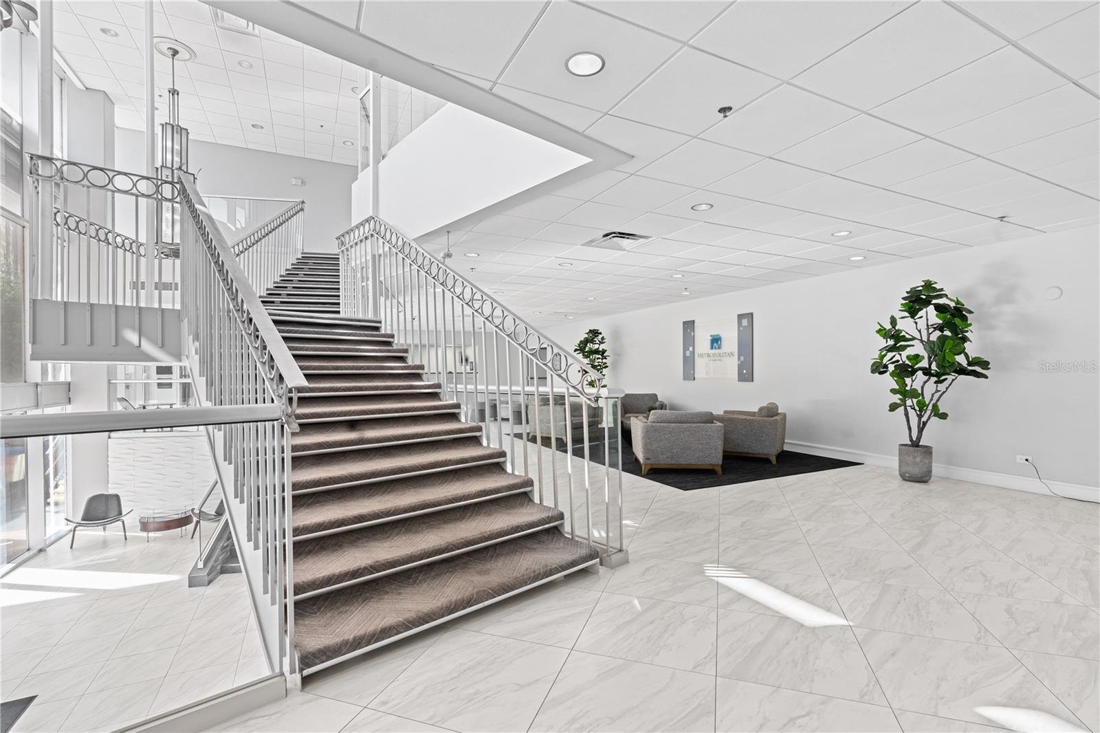 staircase and lobby with white decor and chairs